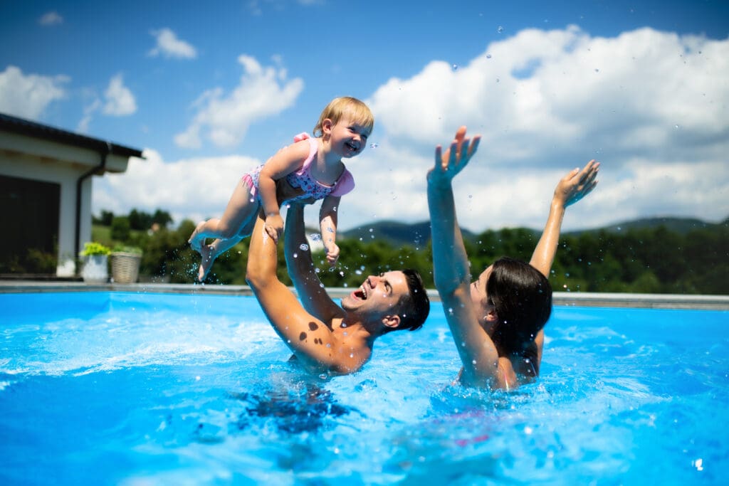 Family enjoying playful time in swimming pool.