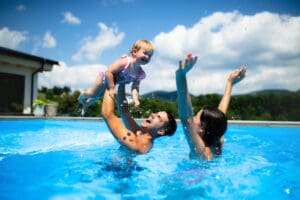 Family enjoying playful time in swimming pool.